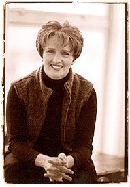 Psychologist Dr. LaCombe sitting on top of a desk with her hands clasped